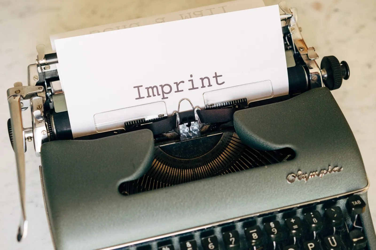 Close-up of a vintage typewriter with the word 'Imprint' on paper, conveying a retro feel.